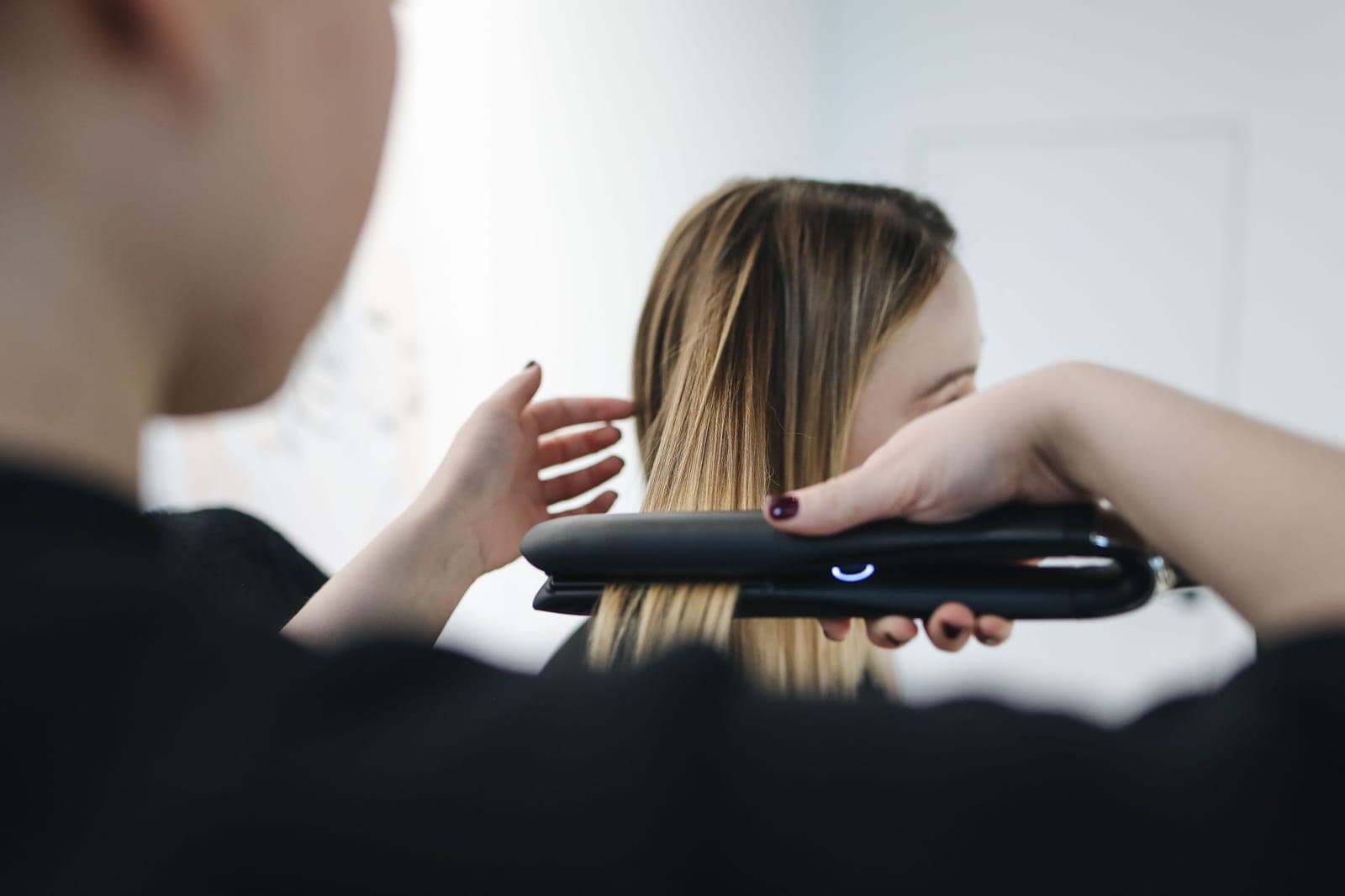A flat iron being used to straighten hair